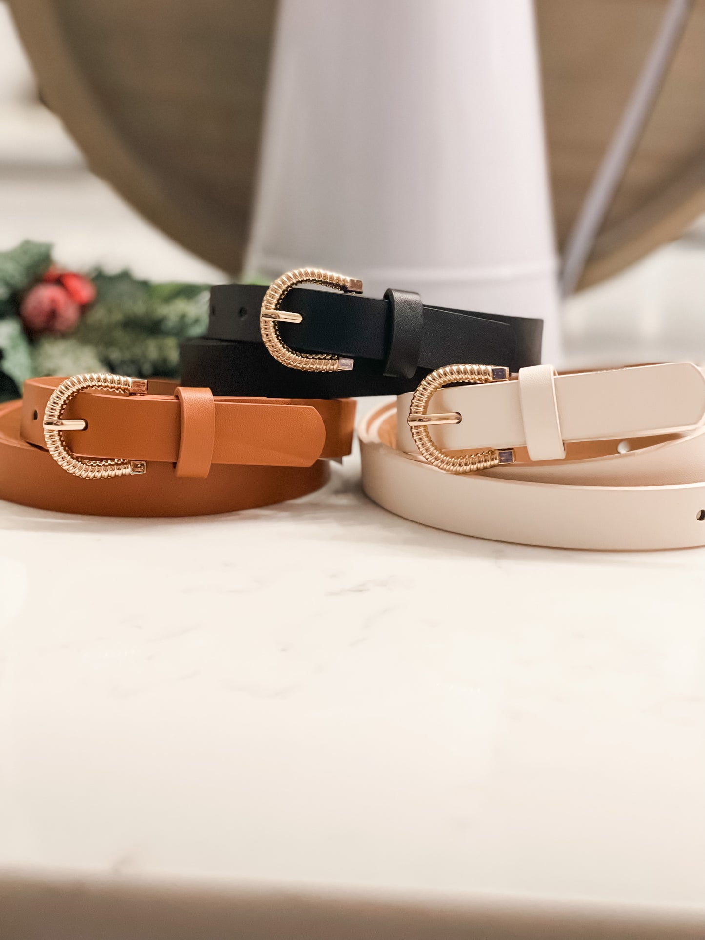 Three womens belts colored brown, black and taupe